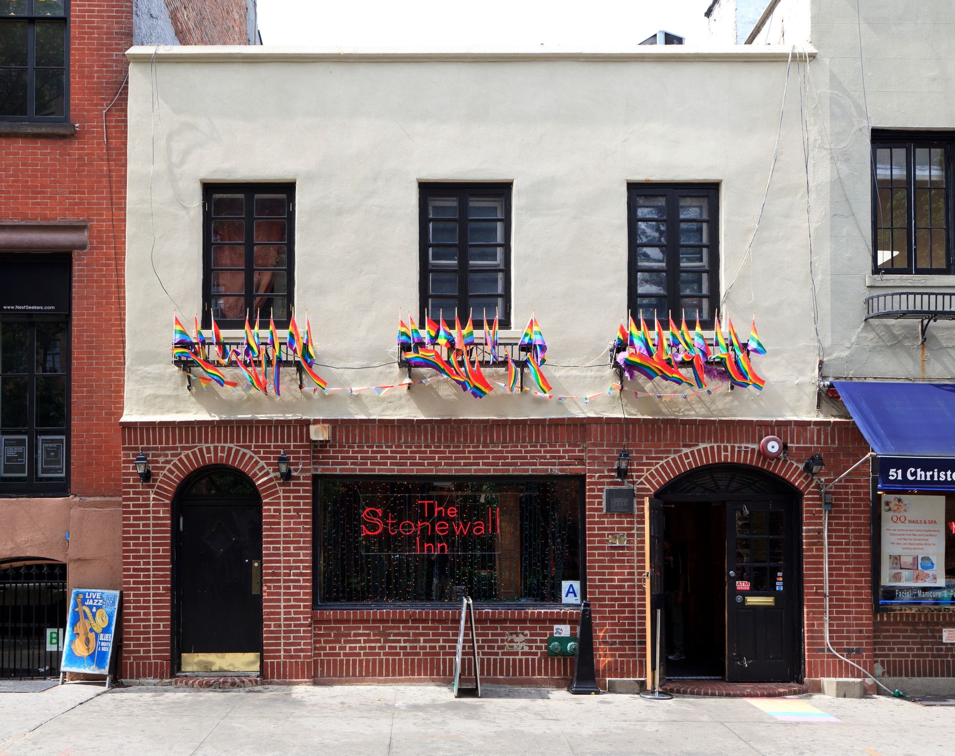 A brick building with a red neon sign that says