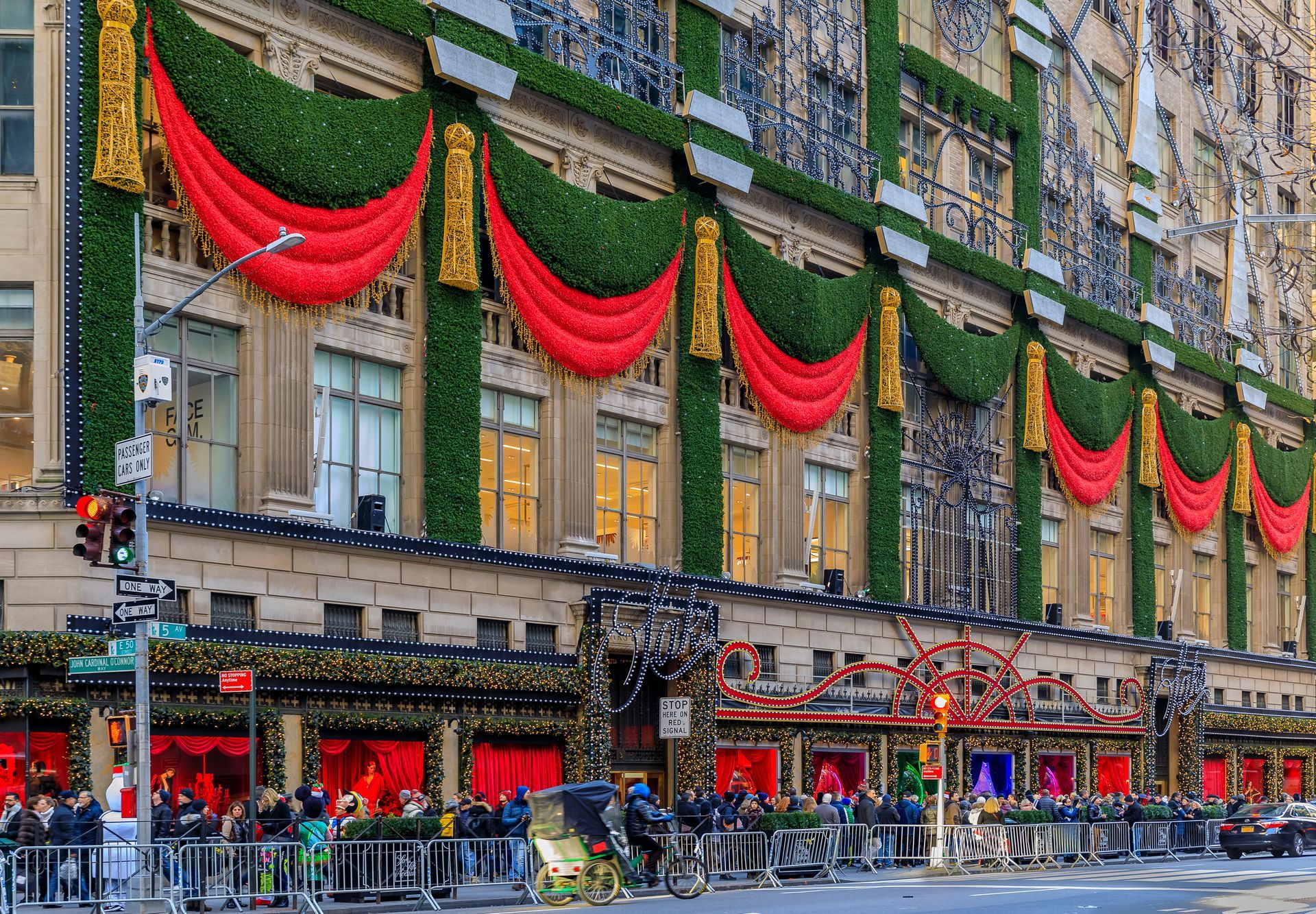 A large building is decorated for christmas with red and green decorations.