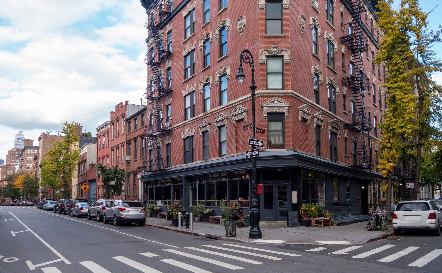A brick building is on the corner of a city street.