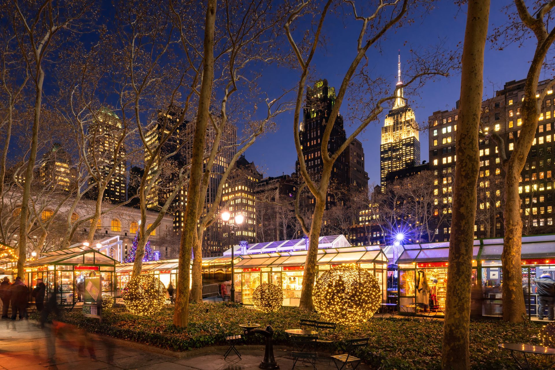 Winter Village at Bryant Park at night with the Empire State building in the background.