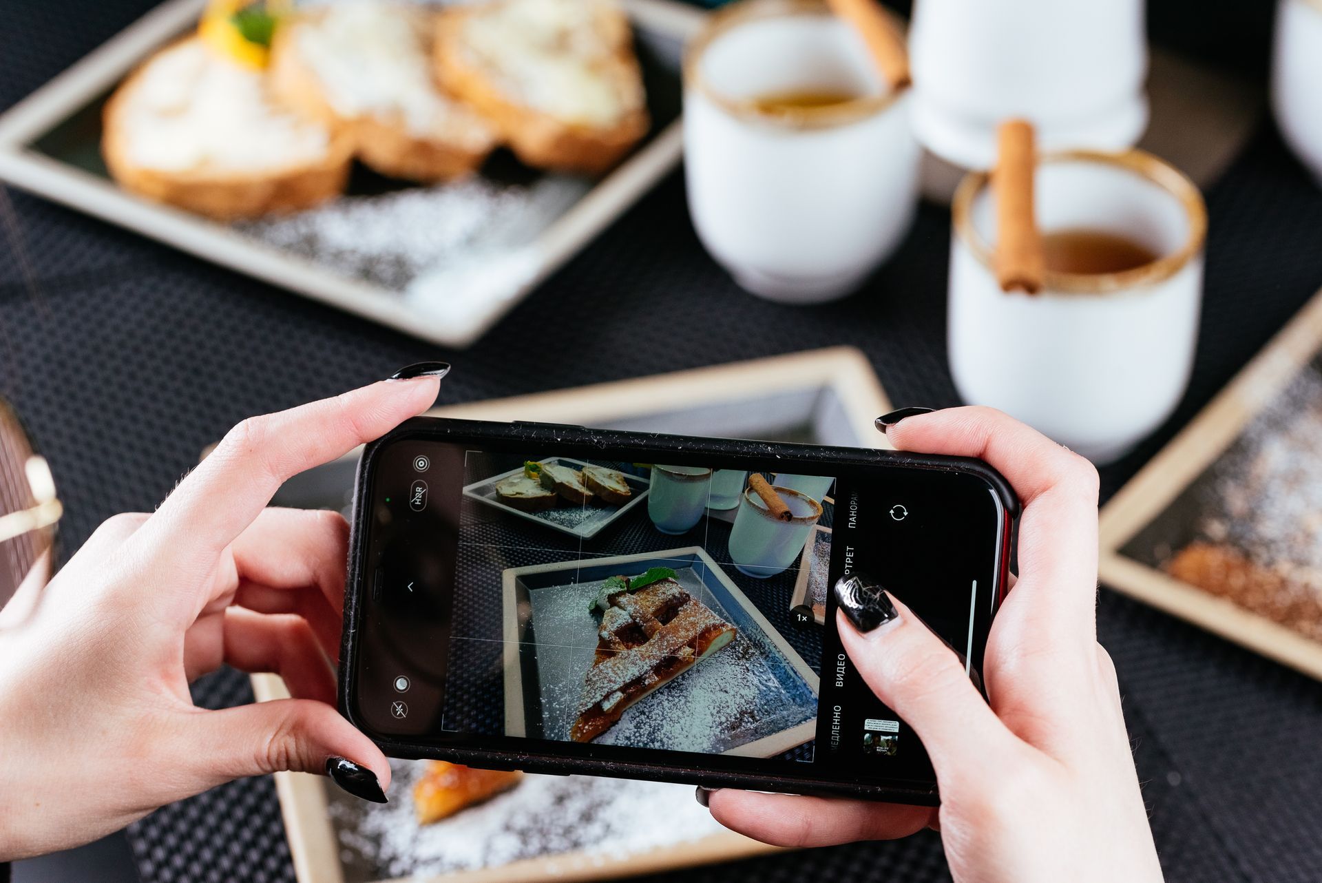 A person is taking a picture of food with a cell phone.