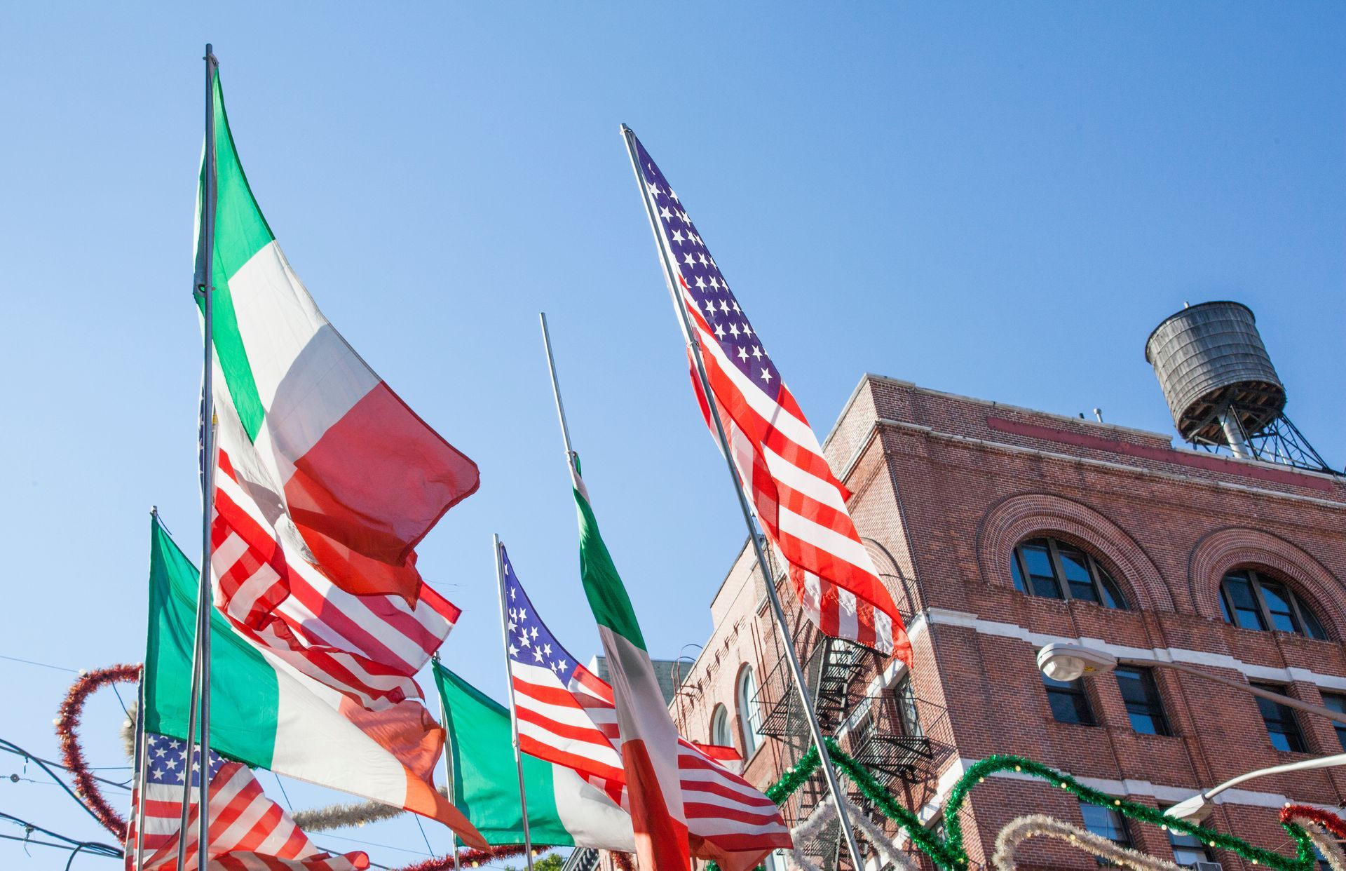 A bunch of Italian flags are flying in front of a building