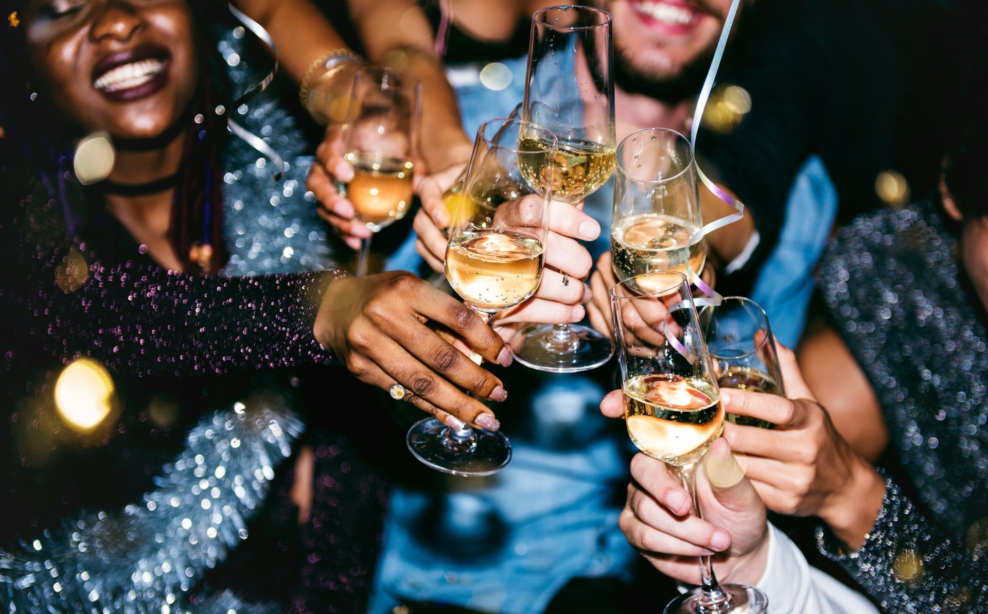 A group of people are toasting with champagne glasses at a party.