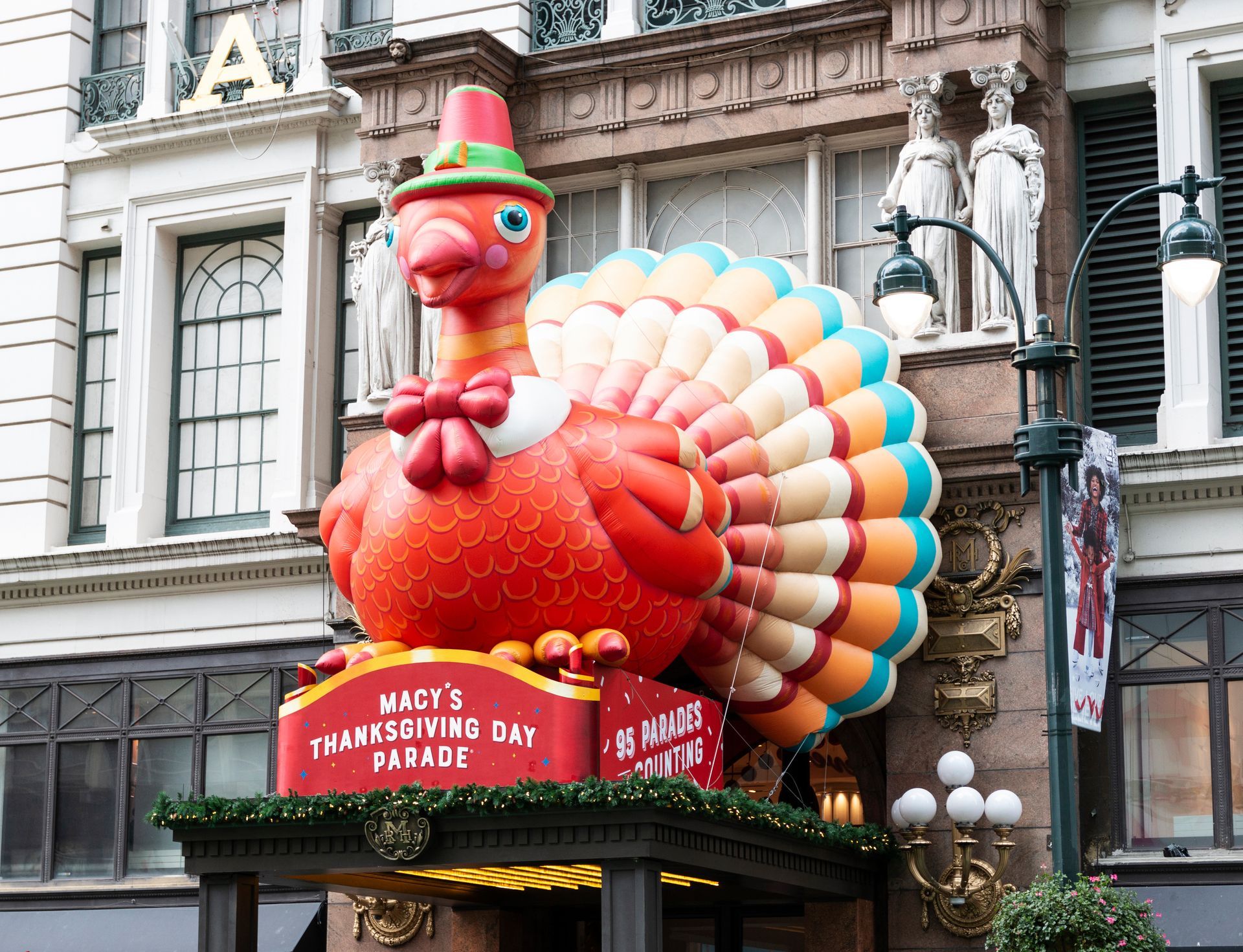 A large inflatable turkey is displayed in front of macy 's thanksgiving day parade