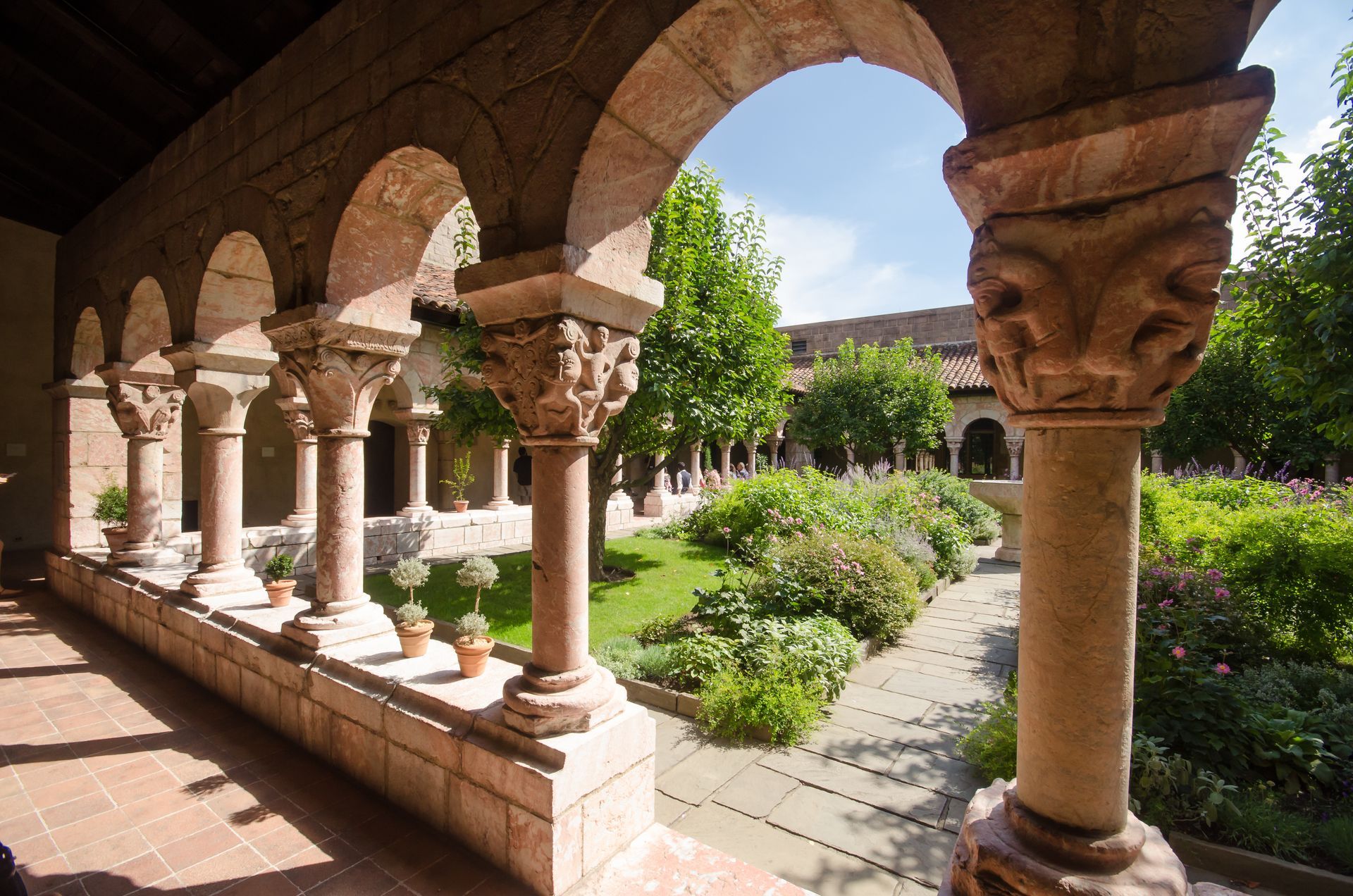 A row of columns in a courtyard with trees in the background