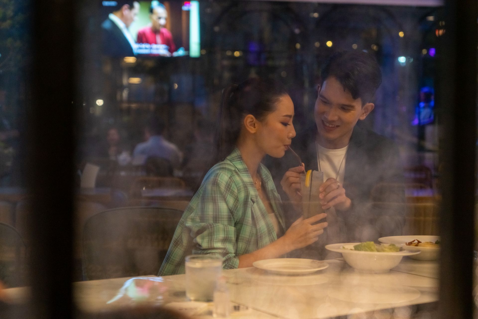 A man and a woman are sitting at a table in a restaurant.