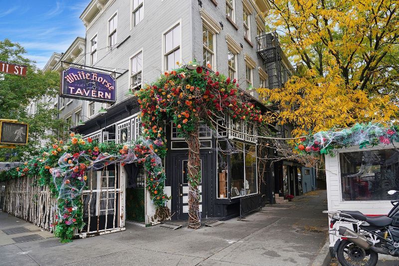a tavern with vines and flowers growing around it