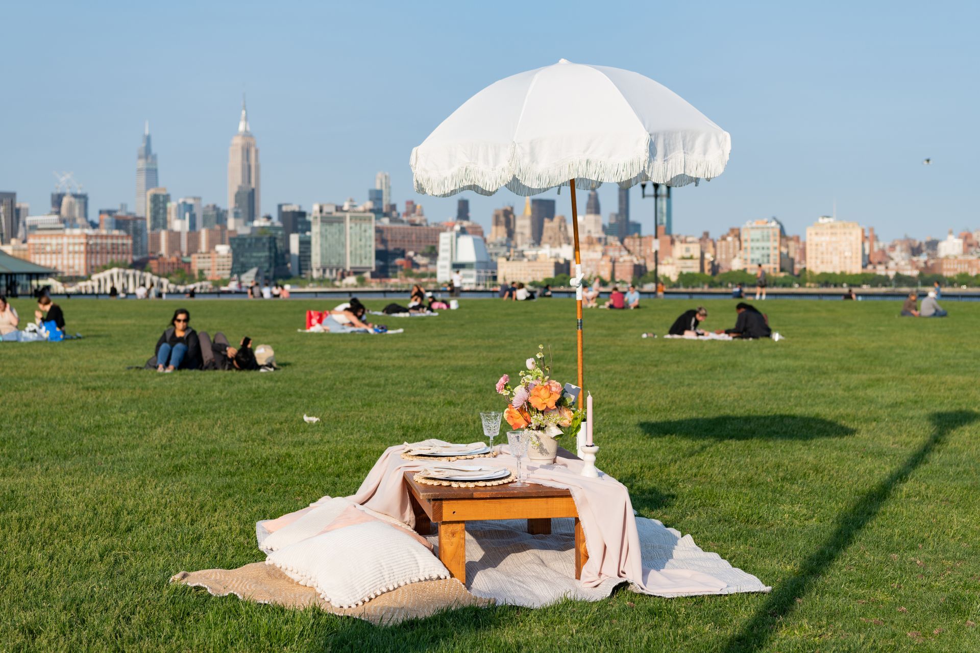 A picnic table is sitting in the middle of a grassy field.