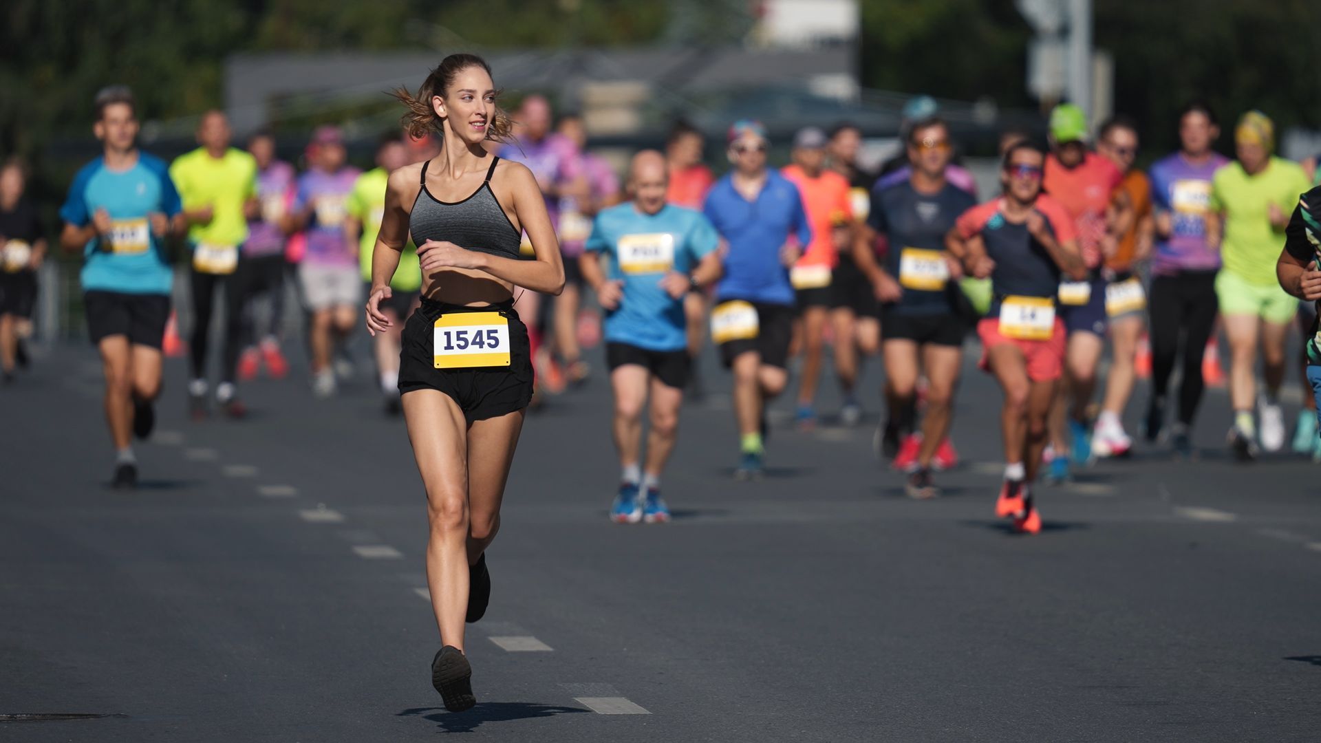 A group of people are running a marathon on a city street.