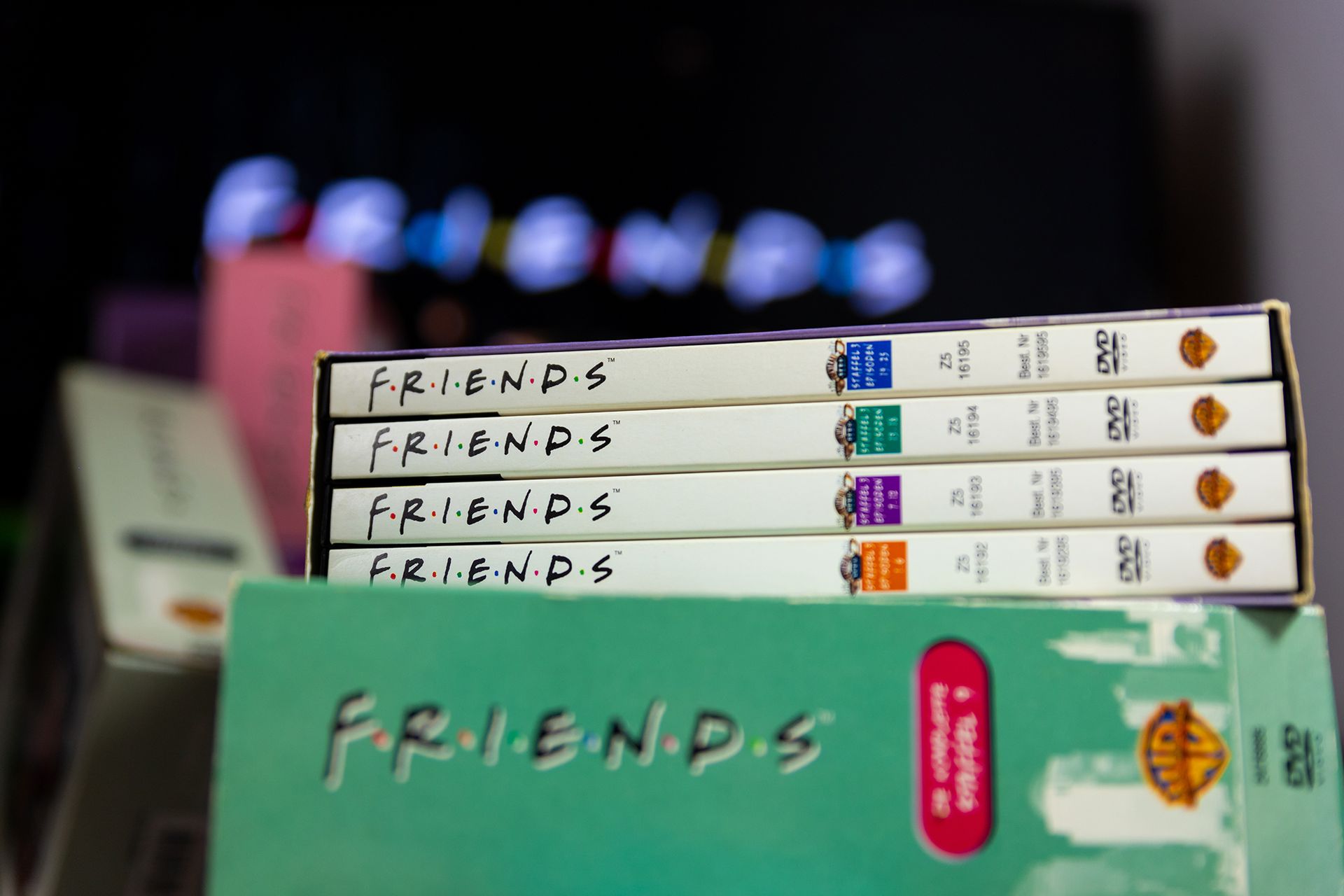 a stack of friends dvds sitting on top of each other on a table .