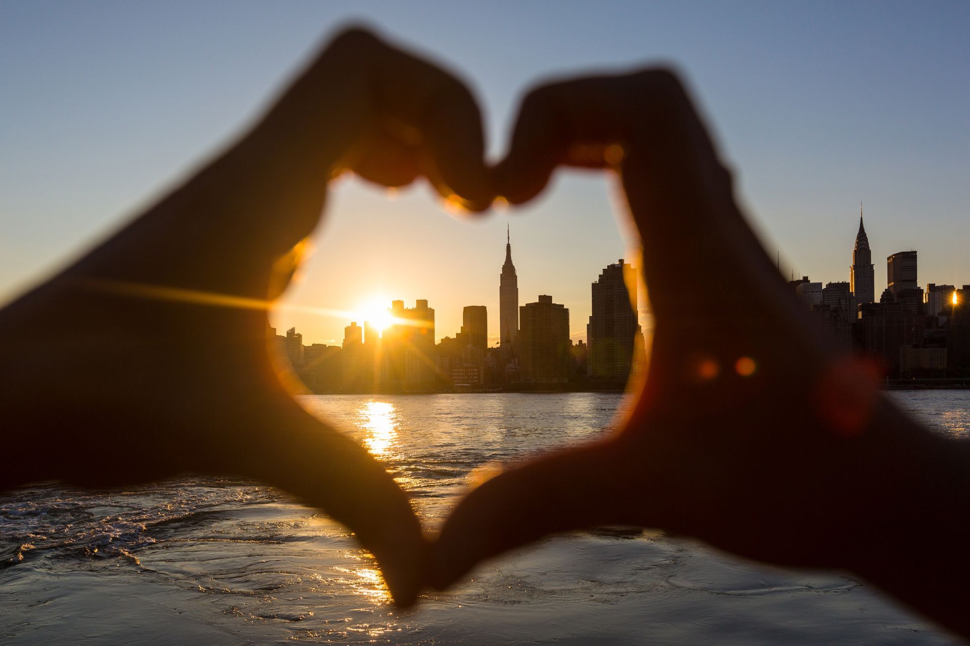 A person is making a heart shape with their hands