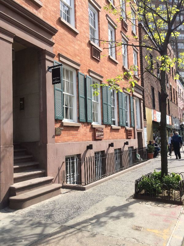 a brick building with green shutters on the windows