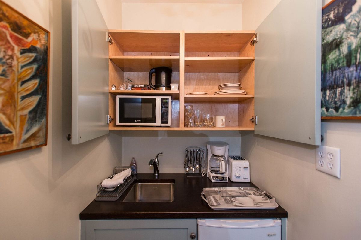 a small kitchen with a sink , microwave , and refrigerator .