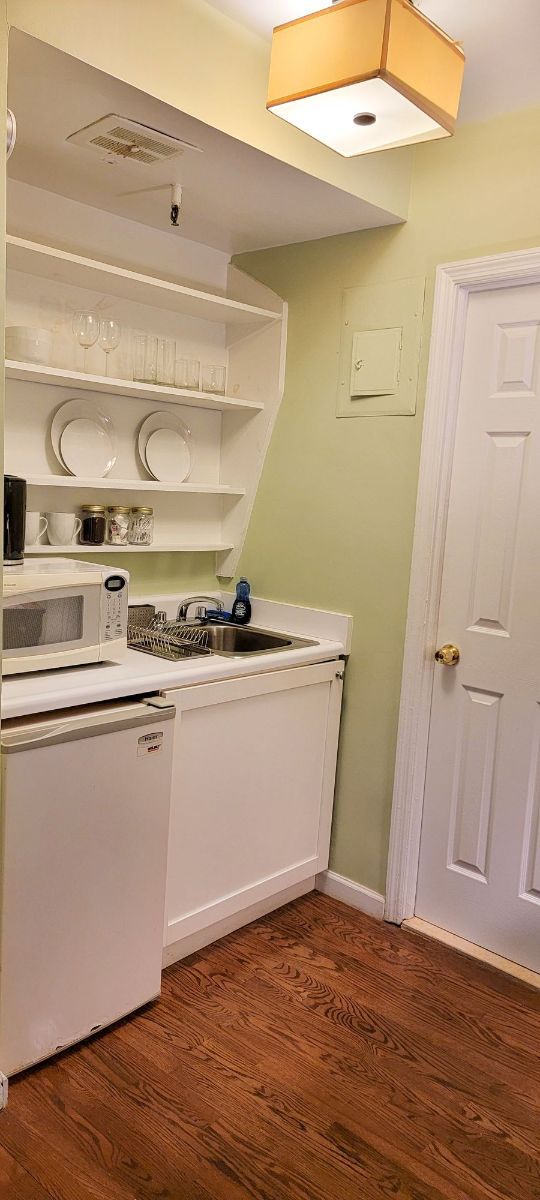 a small kitchen with a sink , microwave , and refrigerator .