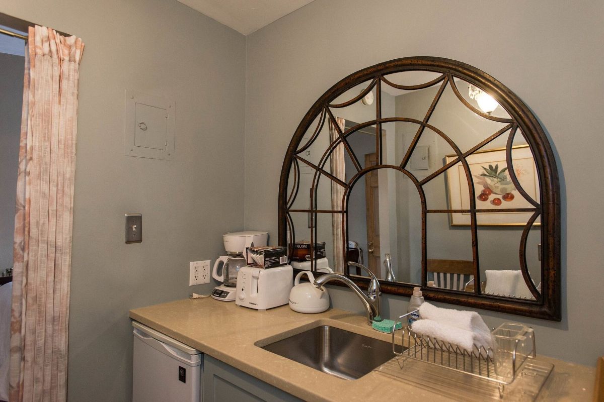 a kitchen counter with a sink and a large mirror .