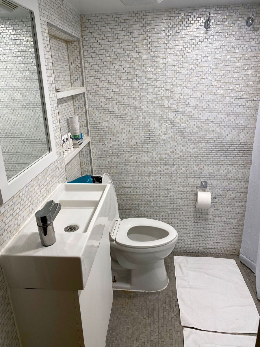 a bathroom with a toilet , sink and mirror .
