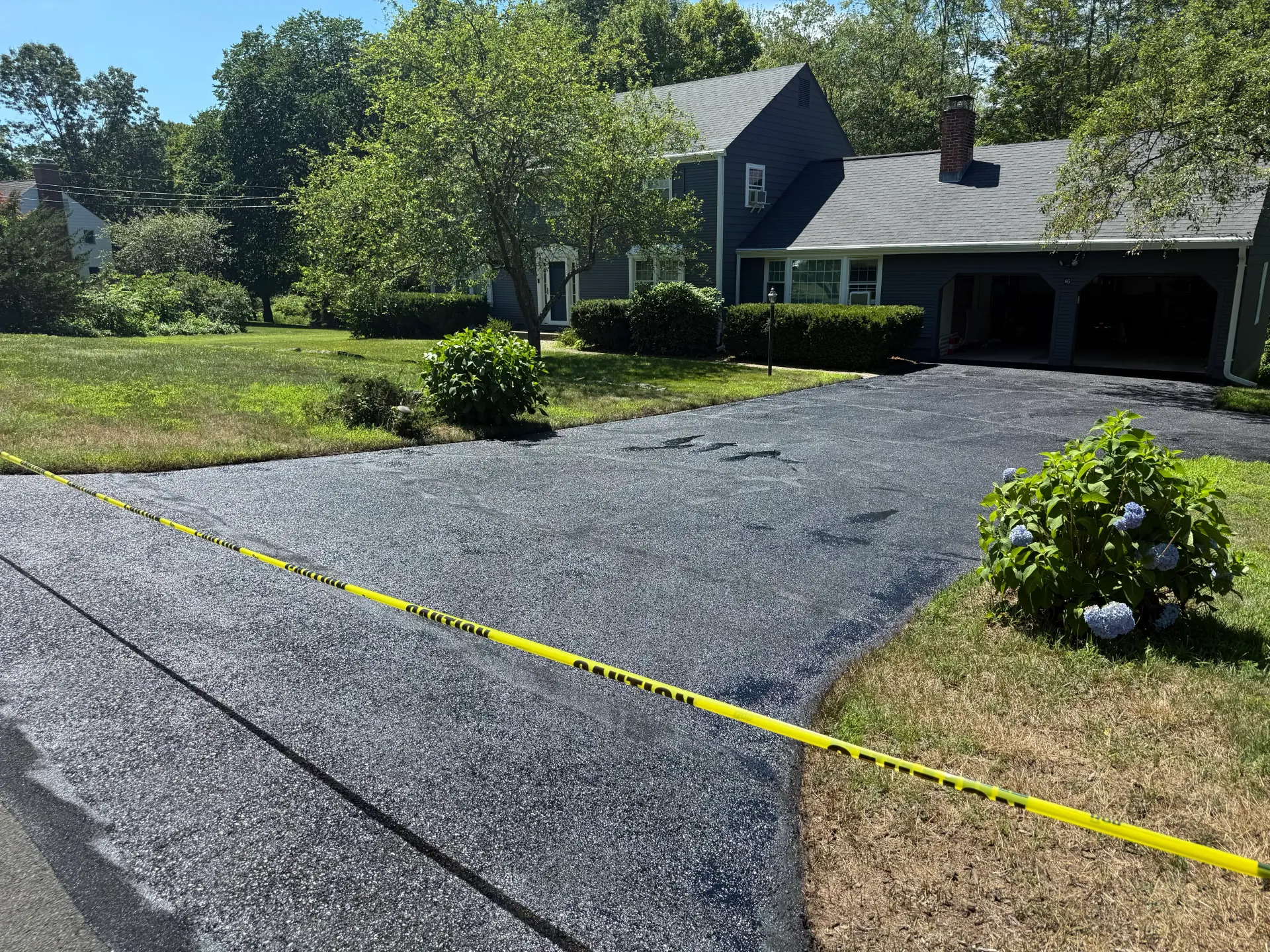 A driveway is being serviced in front of a house.