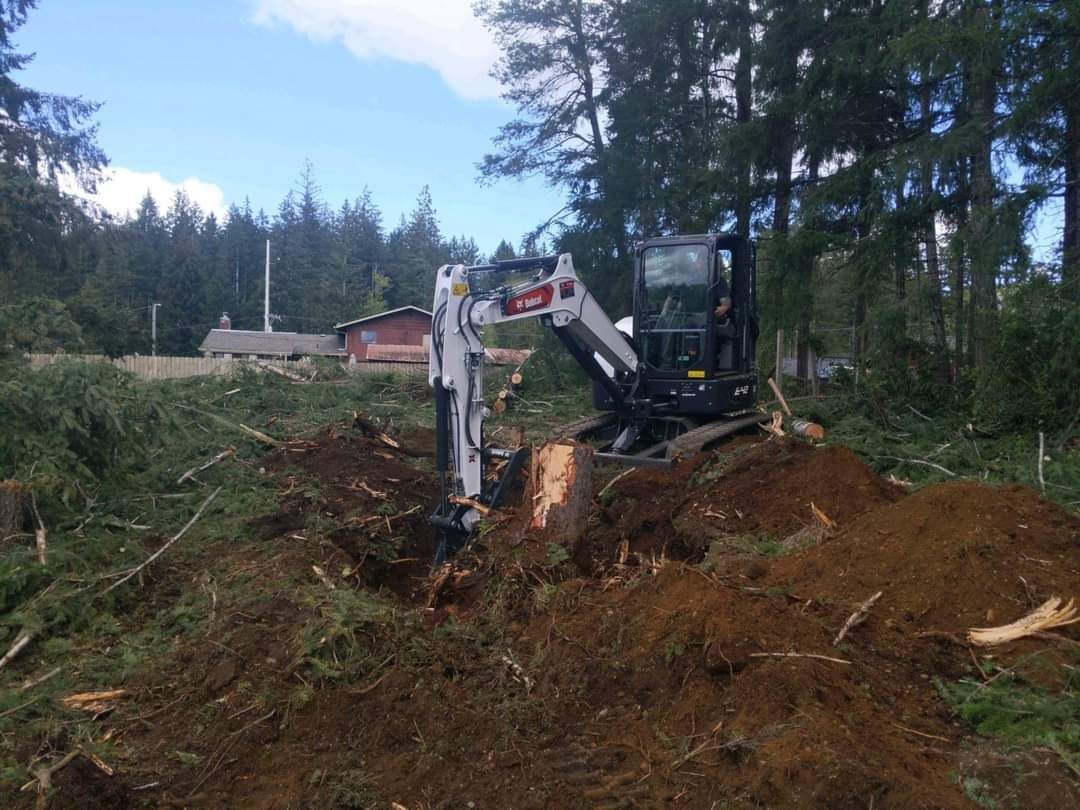 A Small Excavator Is Digging a Hole in A Pile of Dirt - Shelton, WA - D&T Excavating LLP