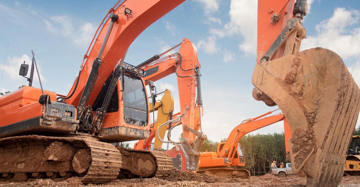 A group of construction vehicles are working on a construction site.