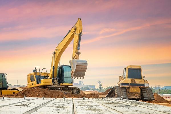 A bulldozer and an excavator are working on a construction site.