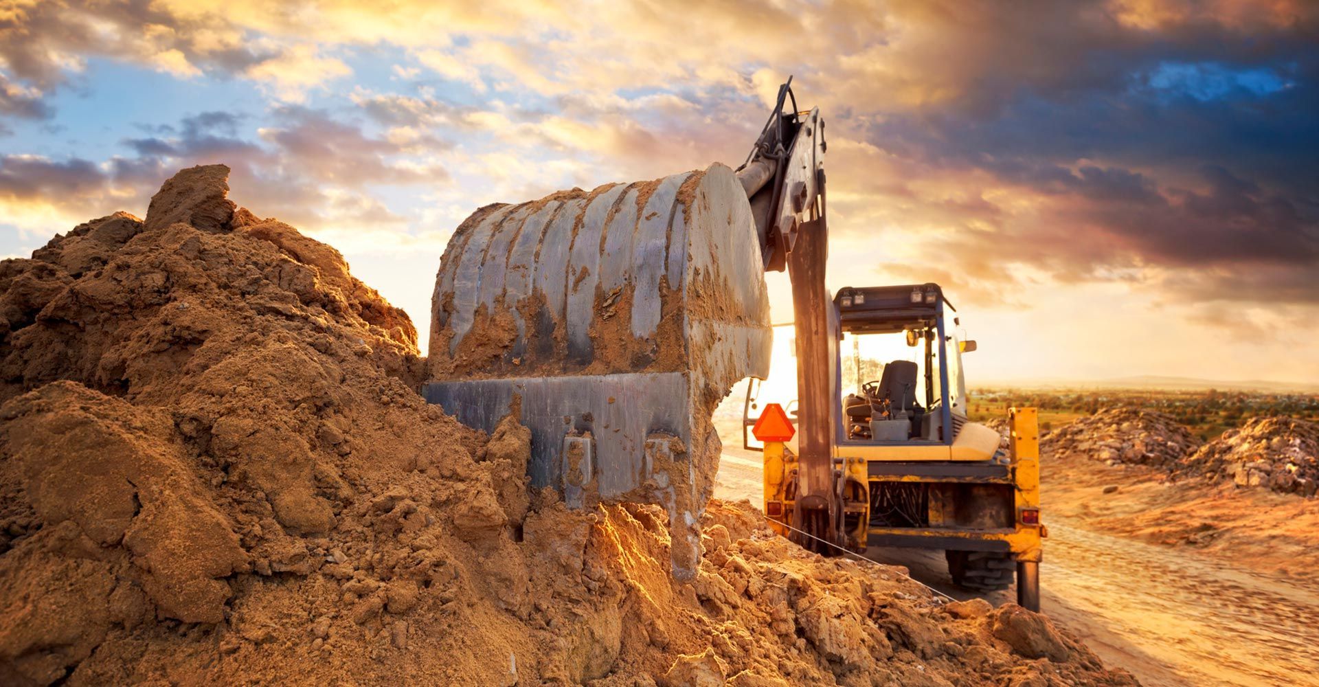 A bulldozer is digging a hole in the ground at a construction site.