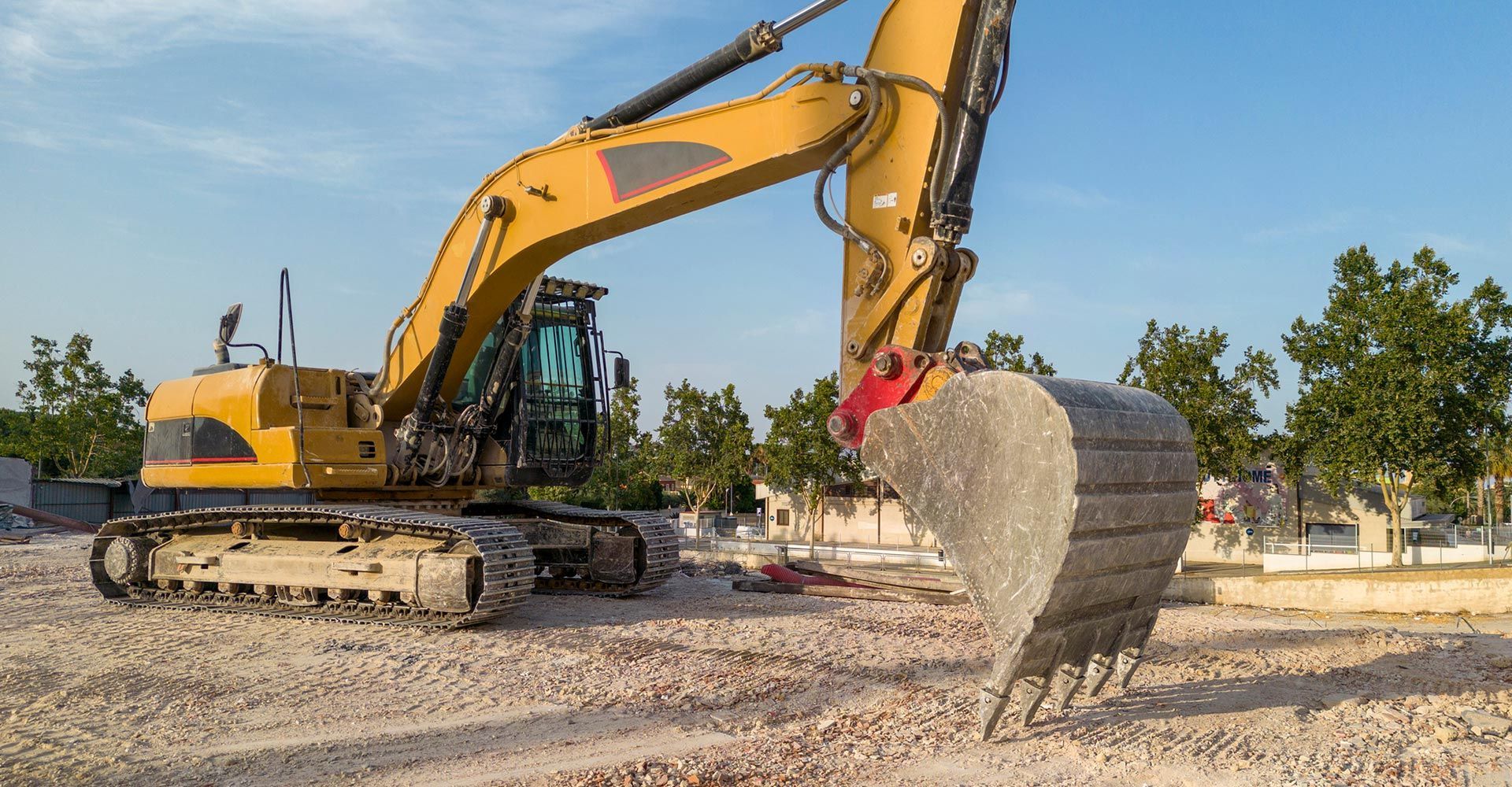 A large yellow excavator is working on a construction site.