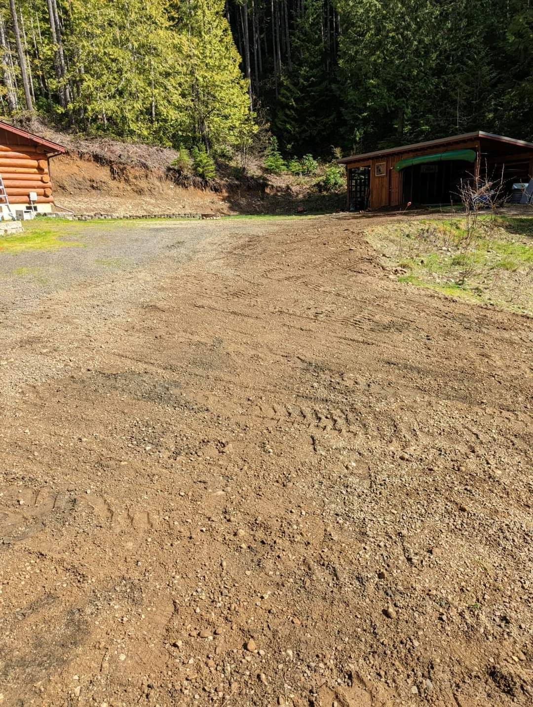 A dirt road leading to a log cabin in the woods.