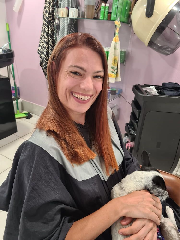 A Woman Is Smiling While Holding A Dog In A Salon — Spiroll Heated Rollers in Redlynch, QLD