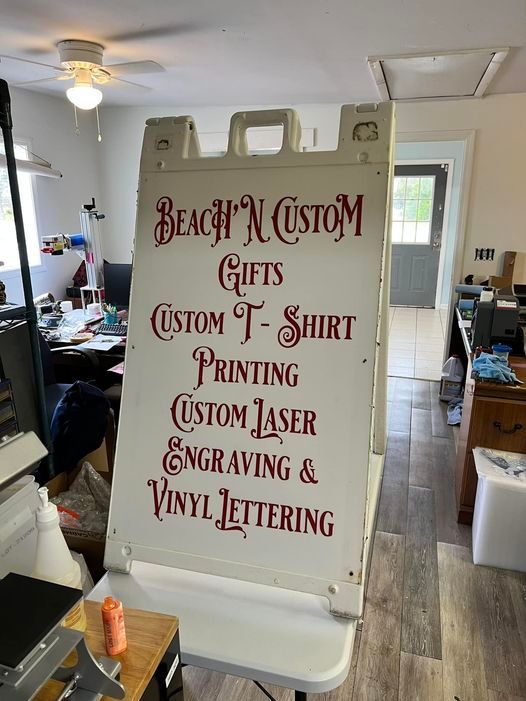 A sign that says beach n custom gifts custom t-shirt printing custom laser engraving and vinyl lettering