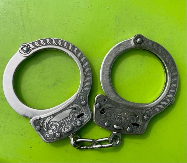 A pair of handcuffs on a green surface
