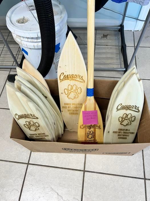 A box of cougars oars sits on a tiled floor