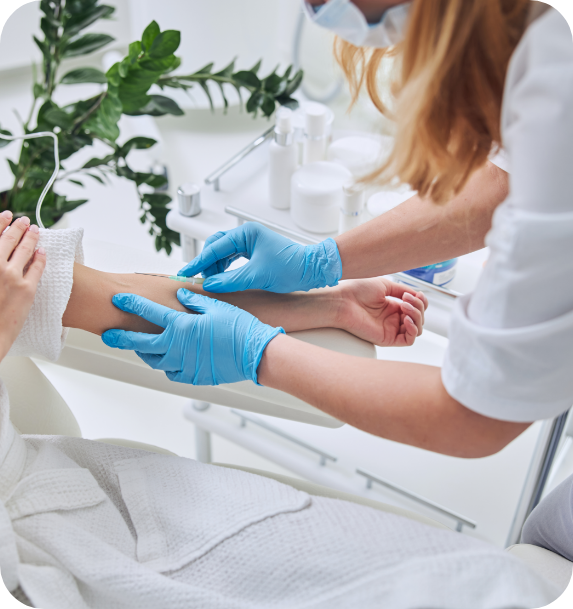A woman wearing blue gloves is examining a patient 's wrist.
