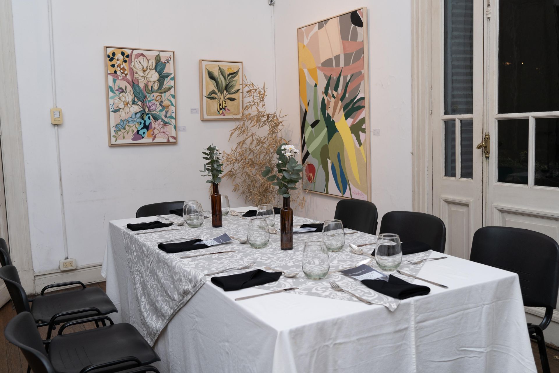Mesa de comedor formal en una habitación con arte en las paredes.