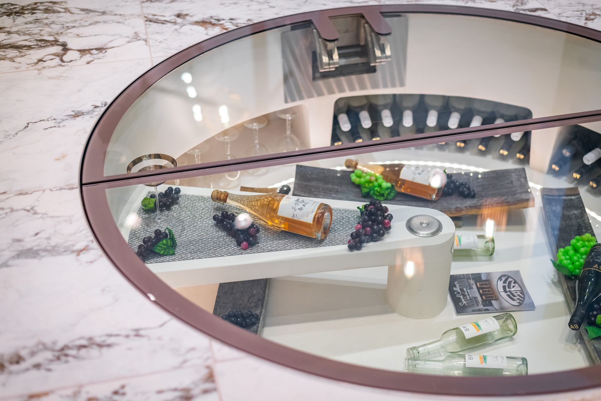 A table with bottles of wine and grapes on it in a wine cellar.