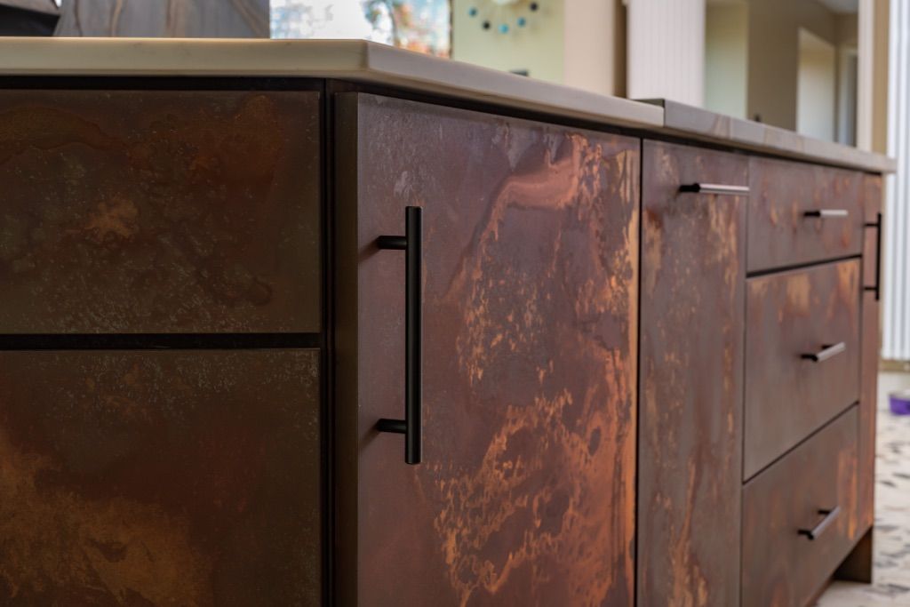A close up of a rusty cabinet with drawers in a kitchen.