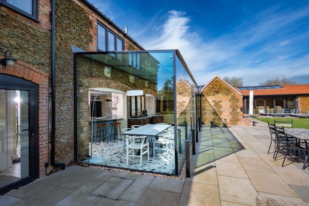 There is a large glass wall between the house and the patio.