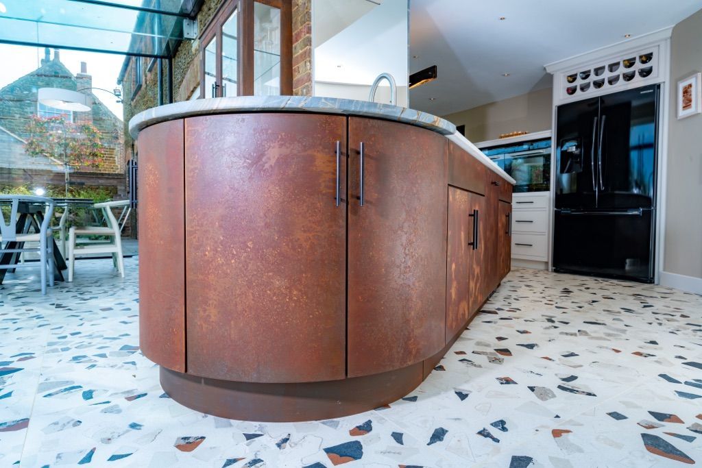 A kitchen with a large island and a terrazzo floor.