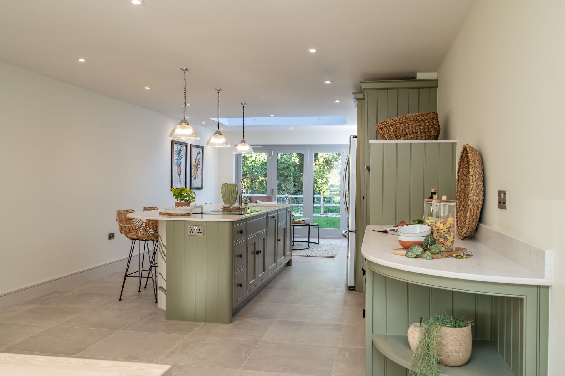 A kitchen with green cabinets and a large island in the middle of the room.