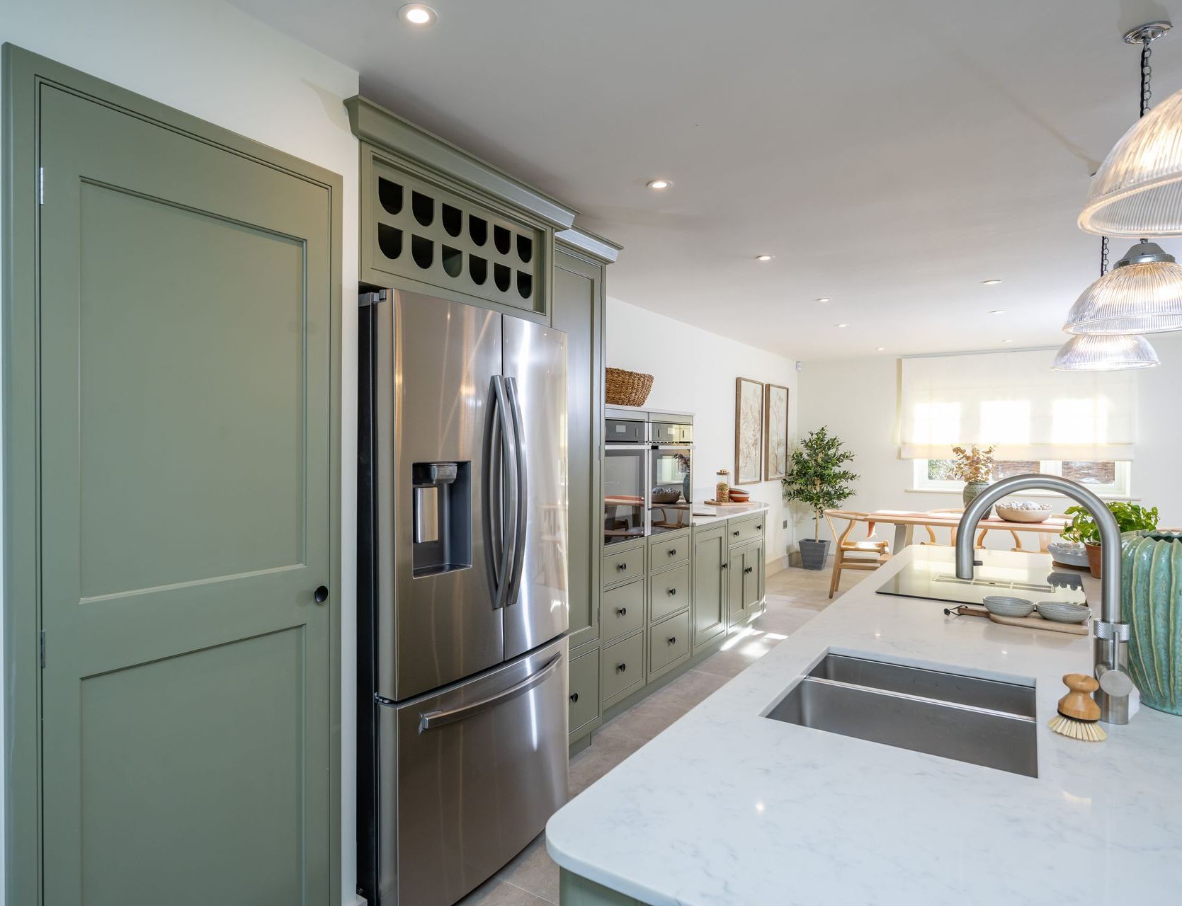 A kitchen with green cabinets and drawers open.
