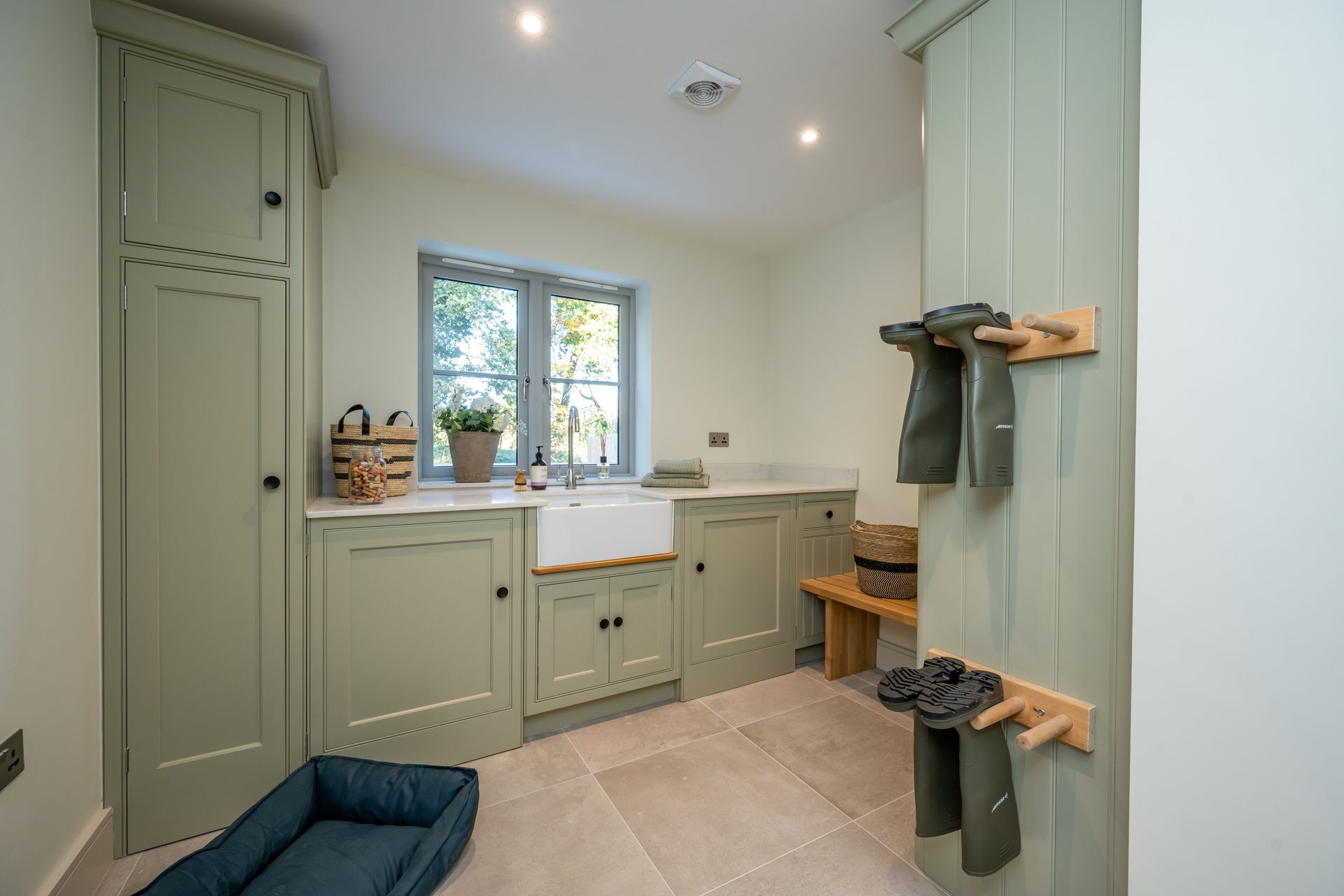 A white kitchen sink is sitting on a counter next to a window.