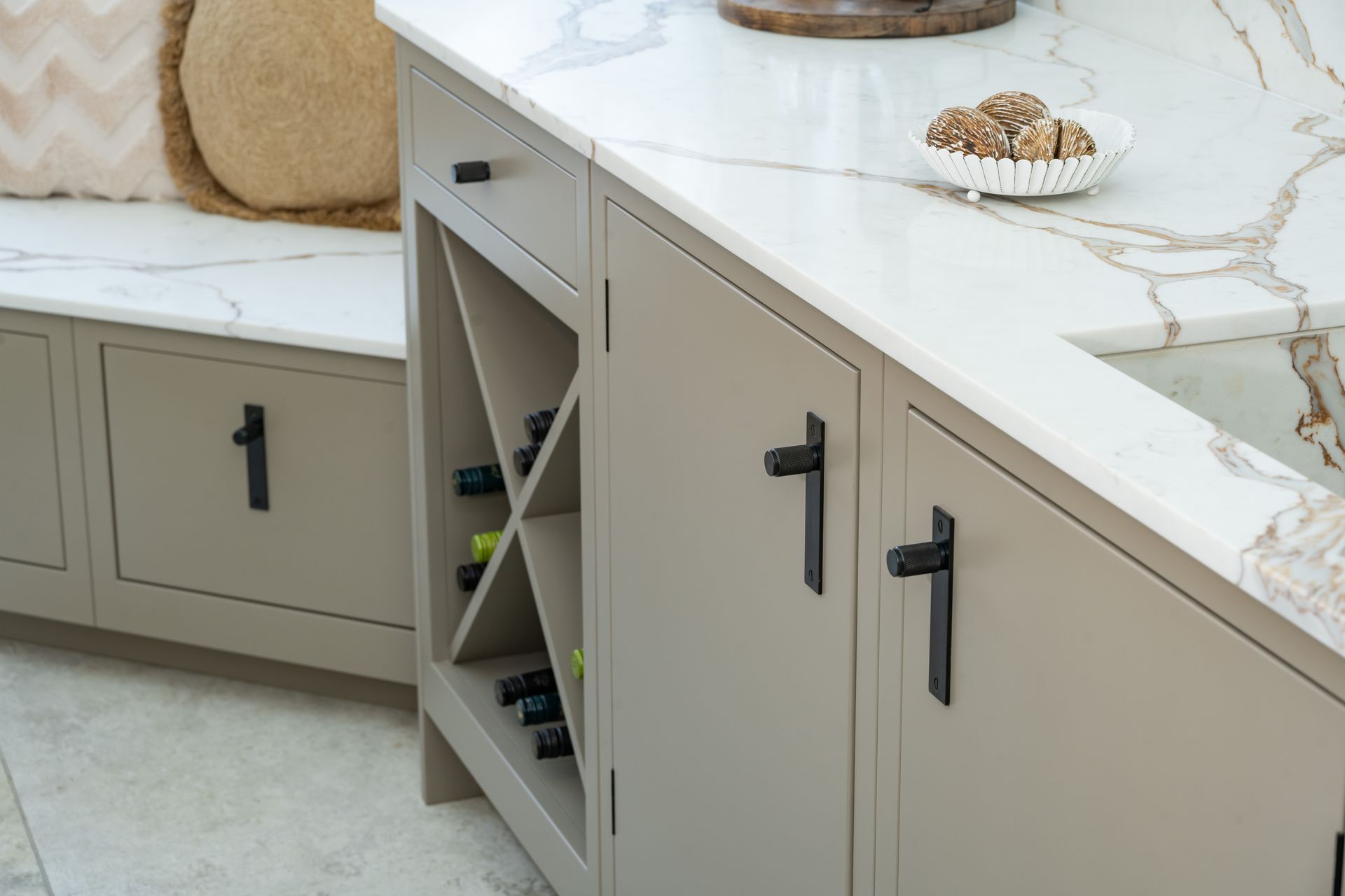A kitchen with a wine rack and a bench.