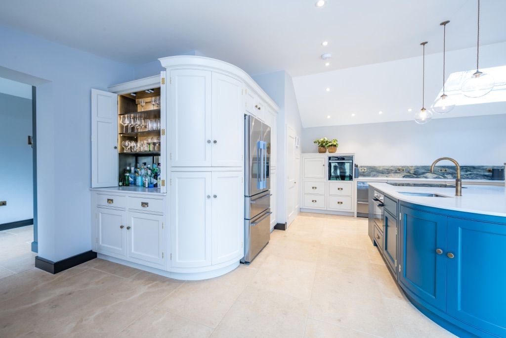A kitchen with blue cabinets and white cabinets and a large island.