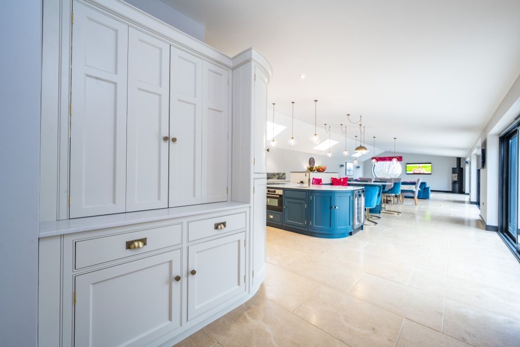 A large kitchen with white cabinets and blue counter tops.