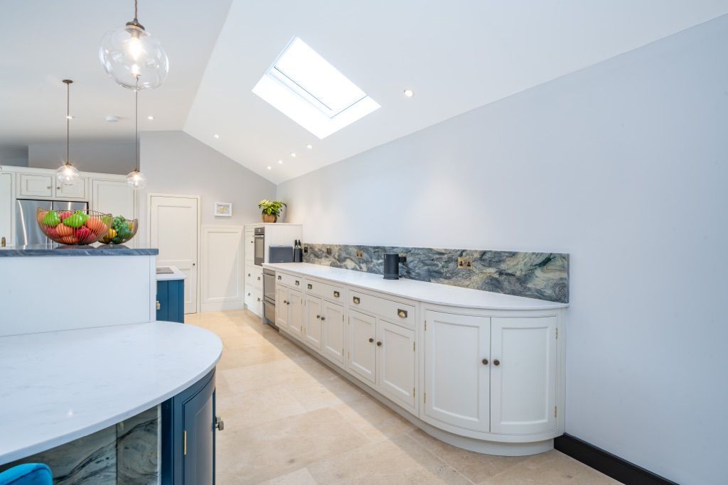 A kitchen with white cabinets and a skylight on the ceiling.