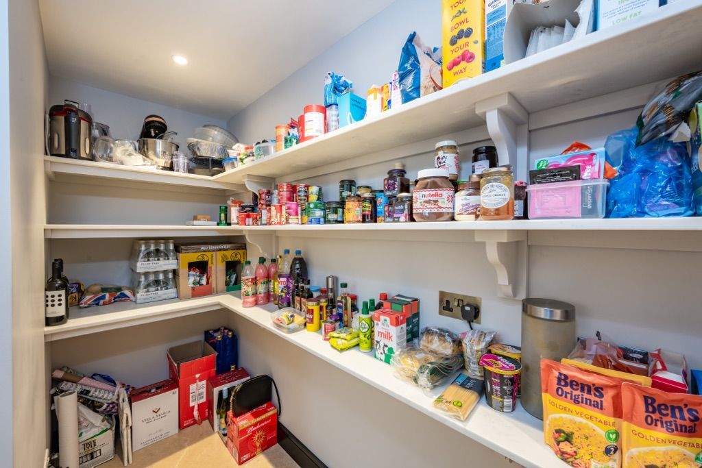 A pantry filled with lots of food and boxes of cereal.