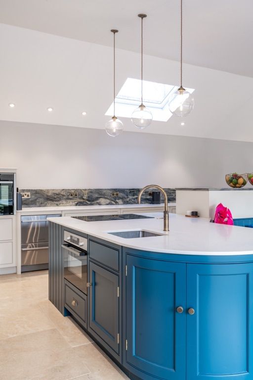 A kitchen with blue cabinets and a white counter top