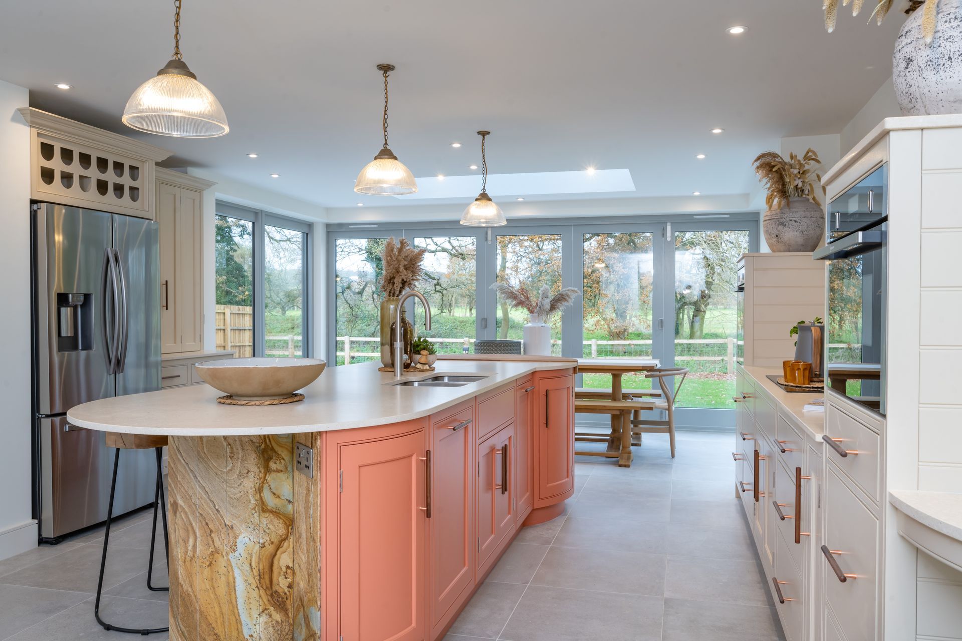 A kitchen with pink cabinets and a large island in the middle.