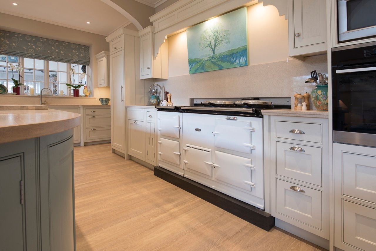 There is a painting on the wall above the stove in the kitchen.