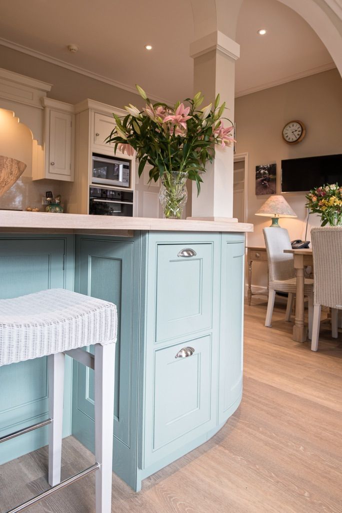 There is a vase of flowers on the counter in the kitchen.