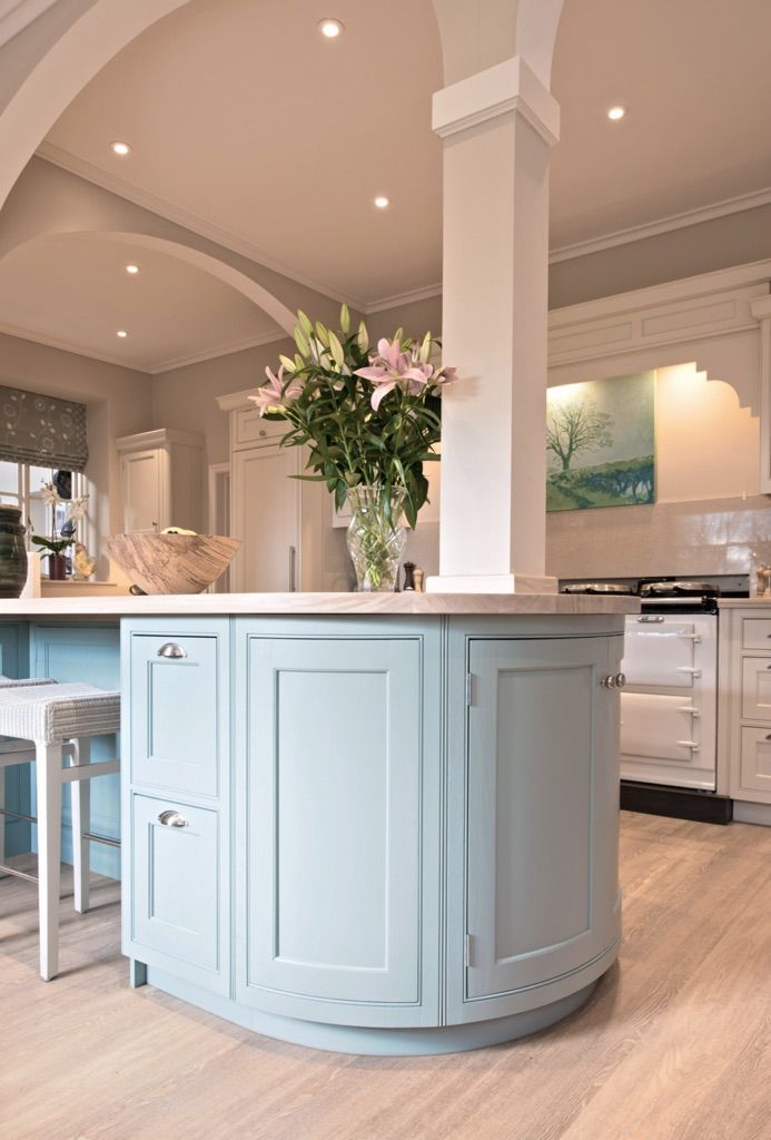 A kitchen with blue cabinets and a vase of flowers on the counter.